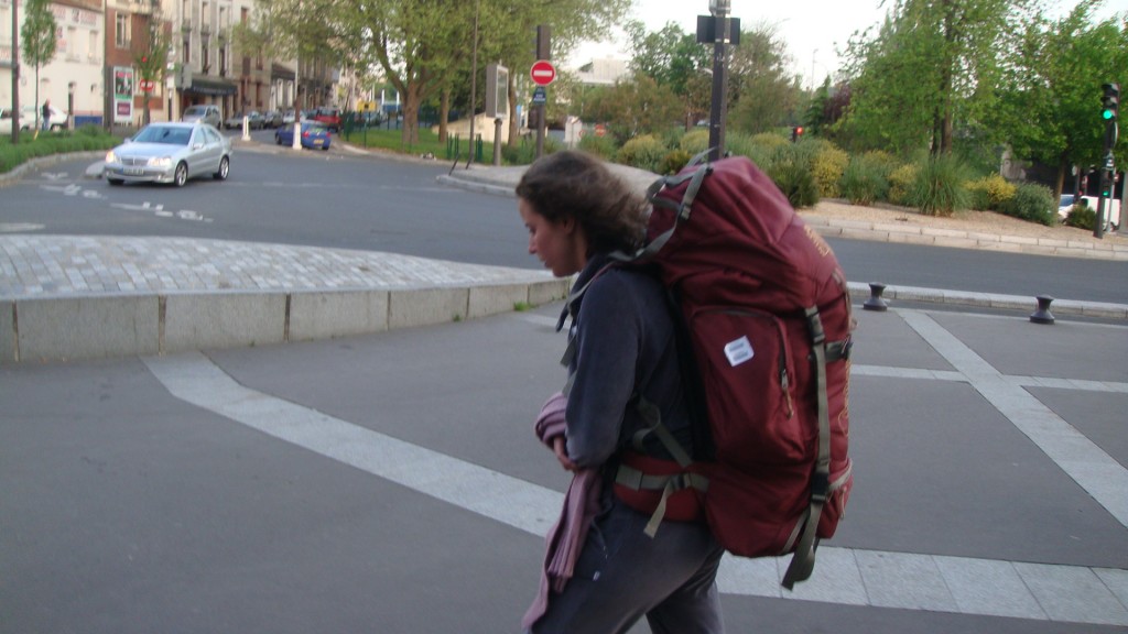 Raquel, autora do blog, caminhando com uma mochila grande de viagem nas costas em seu primeiro mochilão para a Europa em abril de 2009