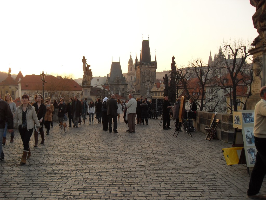 pessoas passeando pela ponte Carlos em um fim de tarde de tempo bom em Praga