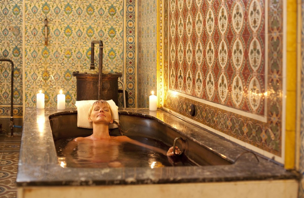 Mulher em uma banheira com olhos fechados relaxando em um ambiente histórico de um spa em Mariánské Lazně