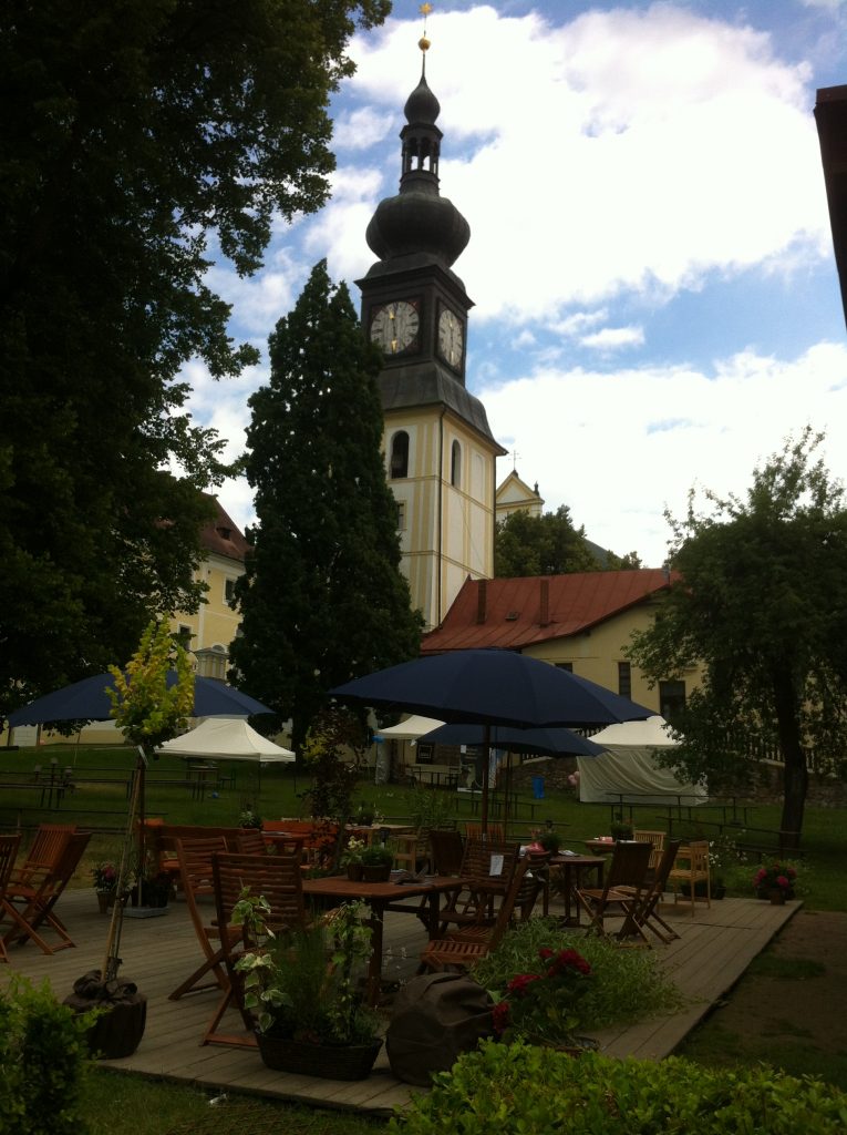 jardim bem cuidade na frente de uma torre medieval de um palácio na cidade tcheca de Zdar nad Sazavou