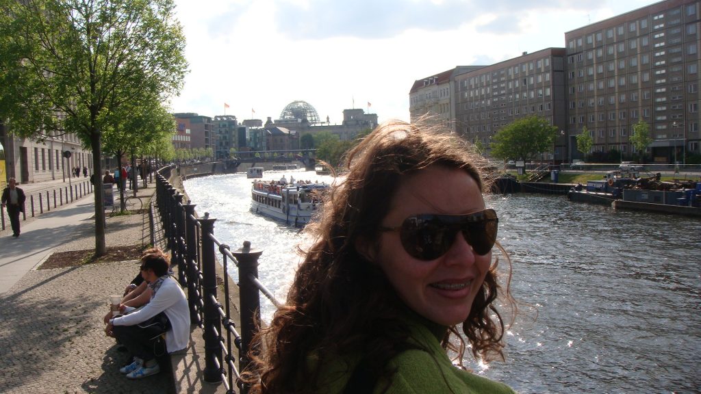 a blogueira Raquel Rezende com o rio da capital alemã ao fundo