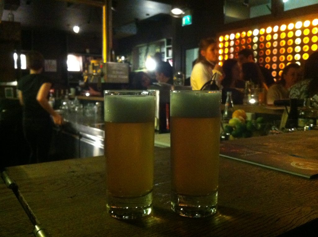 Dois copos de cerveja pequenos no balcão de um bar 