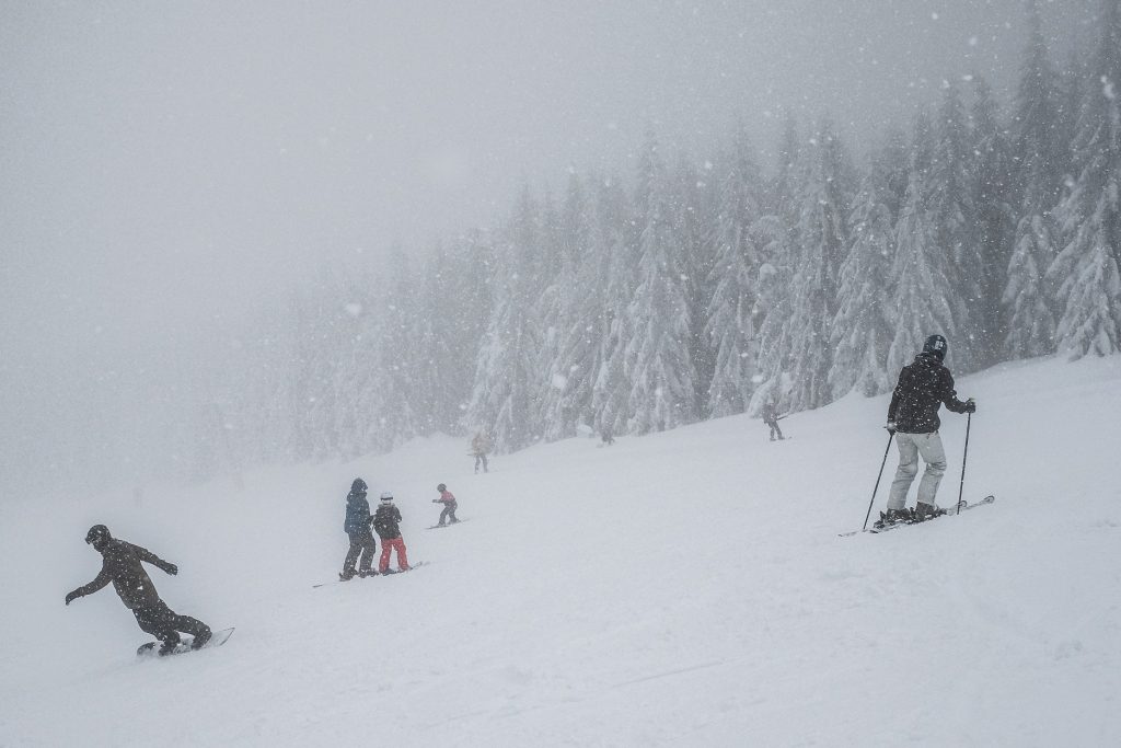 Criança e adulto fazendo snowboard em estação de esqui na República Tcheca