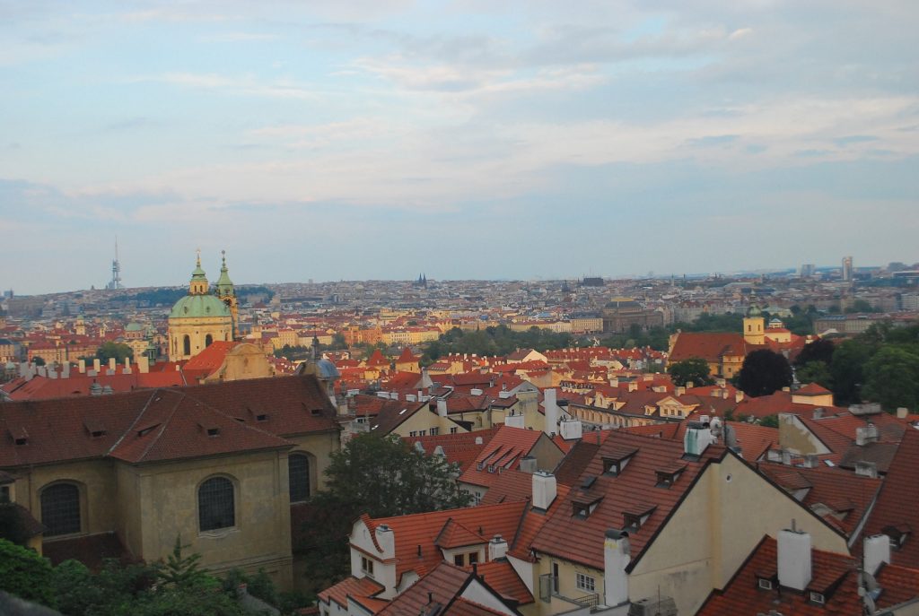 Sol do fim do dia deixando dourado os telhados das casas em Praga