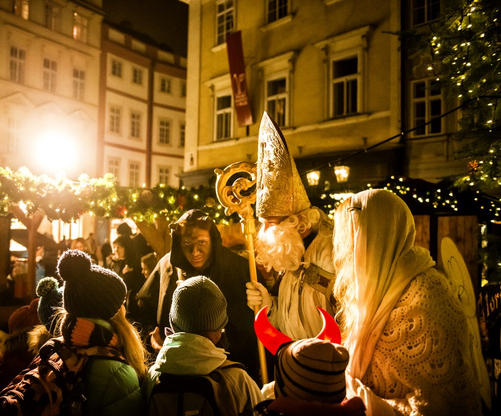 São Nicolau acompanhado do anjo e do diabo nas ruas históricas de Praga. 