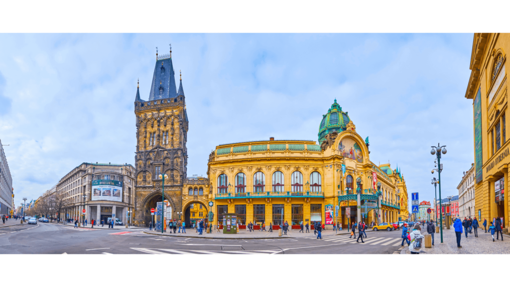 Torre gótica ao lado de um edifício belíssimo em estilo art nouveau na entrada da Cidade Velha de Praga